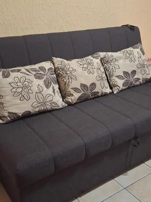 a gray couch with two pillows on it at Apartments D&D Sutomore in Sutomore