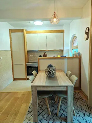 a kitchen with a wooden table and a dining room at Apartman BJANKA in Budva