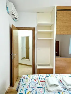 a bedroom with a bed and a closet and a mirror at Apartman BJANKA in Budva