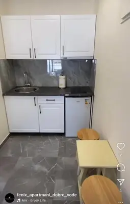 a kitchen with white cabinets and a sink at Fenix Apartmani Dubrava in Dobra Voda