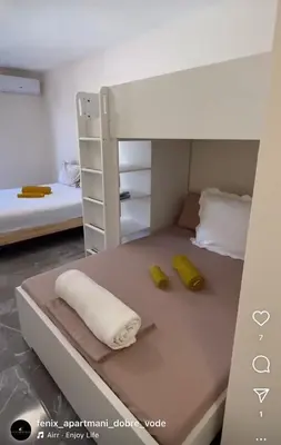 a small bedroom with a bunk bed with two yellow pillows at Fenix Apartmani Dubrava in Dobra Voda