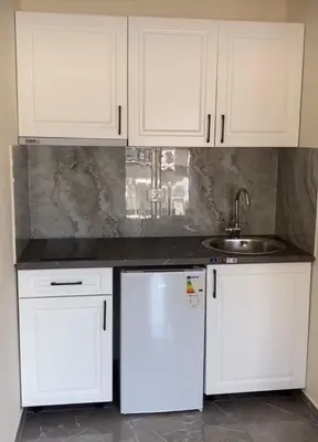 a kitchen with white cabinets and a sink at Fenix Apartmani Dubrava in Dobra Voda