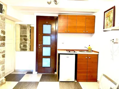 a kitchen with wooden cabinets and a refrigerator at Apartments Bella in Kotor