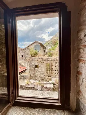 a window with a view of a stone building at Apartments Bella in Kotor