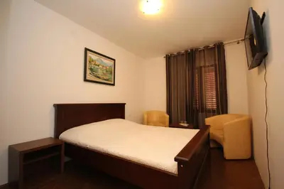 a small bedroom with a bed and a television at Apartment Biba in Virpazar