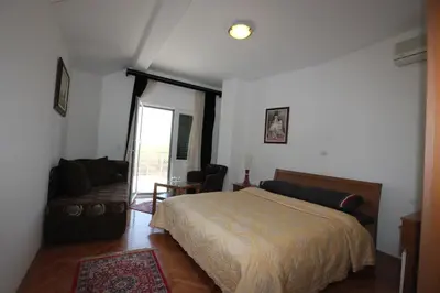 a bedroom with a bed and a couch at Apartment Biba in Virpazar