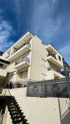 a tall building with a staircase in front of it at Apartmani Bar Zeleni Pojas in Bar
