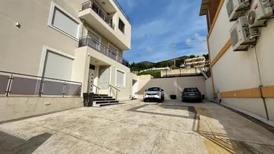 two cars parked in a parking lot next to a building at Apartmani Bar Zeleni Pojas in Bar
