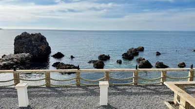 a group of rocks in the water next to a fence at Apartmani Bar Zeleni Pojas in Bar