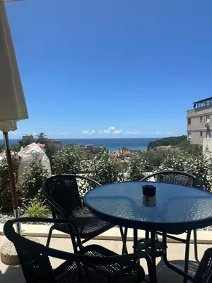 a table and chairs on a patio with a view of the ocean at Nicks sea view appartement II in Petrovac na Moru
