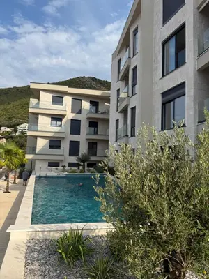 an apartment building with a swimming pool in front of it at Nicks sea view appartement II in Petrovac na Moru