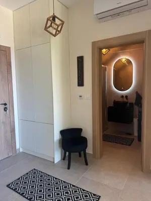 a hallway with a black chair and a television at Nicks sea view appartement II in Petrovac na Moru