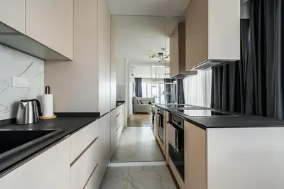 a kitchen with white cabinets and black counter tops at Como residence by InProperty in Budva