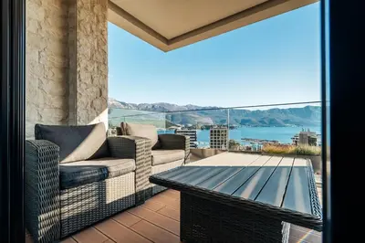 a balcony with a table and chairs and a view of the water at Como residence by InProperty in Budva