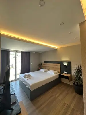a bedroom with a large bed and a large window at Vue Mer in Ulcinj