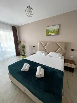 a bedroom with a large bed with white shoes on it at Vue Mer in Ulcinj