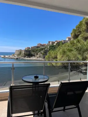 a table and chairs on a balcony with a view of the ocean at Vue Mer in Ulcinj