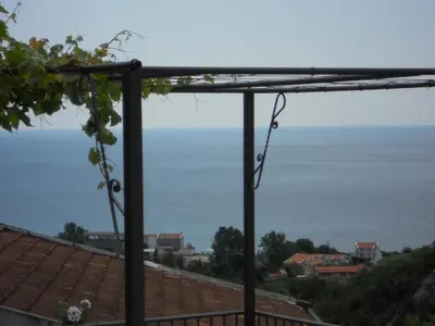 a view of the ocean from the balcony of a house at Apartment Djukovic in Petrovac na Moru