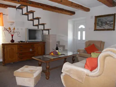 a living room with a tv and a couch and a table at Apartment Djukovic in Petrovac na Moru