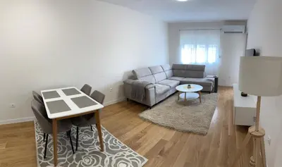 a living room with a couch and a table at Stylish one bedroom apartment Central Point with -GARAGE 5 EUR PER DAY in Podgorica