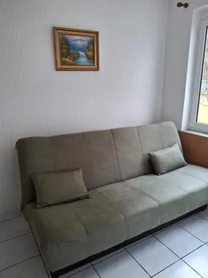 a couch in a living room with a picture on the wall at Adriatica 1 in Sutomore