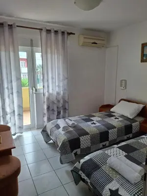 two beds in a room with a window at Adriatica 1 in Sutomore