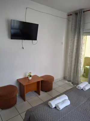 a living room with a table and a tv on the wall at Adriatica 1 in Sutomore