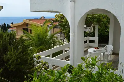 a balcony with a table and a view of the ocean at Apartment Zeleny Pojas in Bar