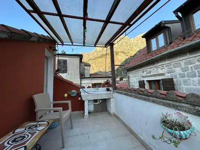 a patio with a table and a bench on a building at Charming apartment with a terrace in Kotor