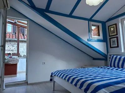 a bedroom with a blue and white striped ceiling at Charming apartment with a terrace in Kotor
