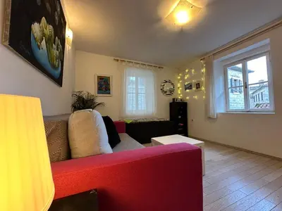 a living room with a red couch and a window at Charming apartment with a terrace in Kotor