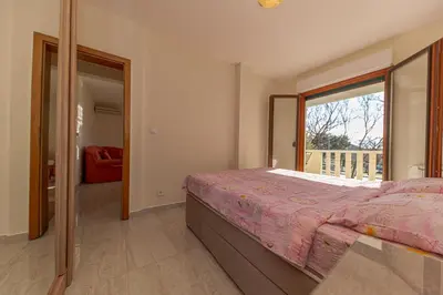 a bedroom with a bed and a large window at Apartment Sofija Petrovac in Petrovac na Moru