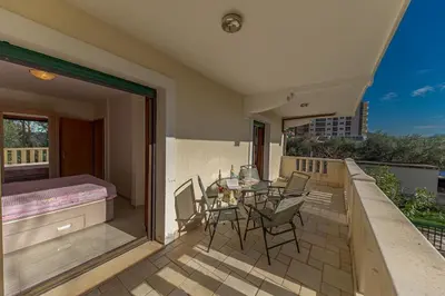 a balcony with a bed and a table and chairs at Apartment Sofija Petrovac in Petrovac na Moru