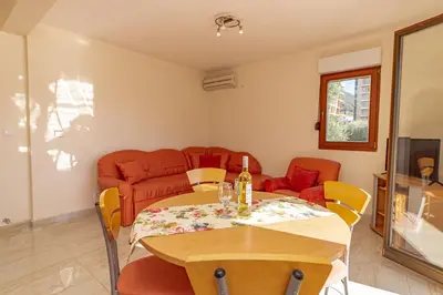 a living room with a table and a couch at Apartment Sofija Petrovac in Petrovac na Moru
