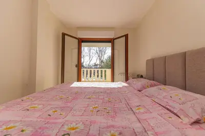 a bedroom with a large bed with a pink comforter at Apartment Sofija Petrovac in Petrovac na Moru