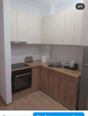 a kitchen with white cabinets and a sink and a stove at Studio in Budva