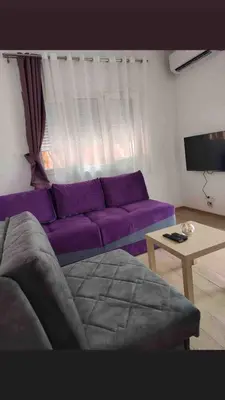 a living room with a purple couch and a table at Studio in Budva