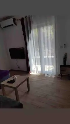 a living room with a couch and a table and a large window at Studio in Budva