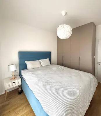 a bedroom with a blue and white bed and a lamp at Apartment Simovic in Cetinje