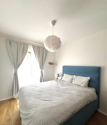a bedroom with a blue bed and a large window at Apartment Simovic in Cetinje