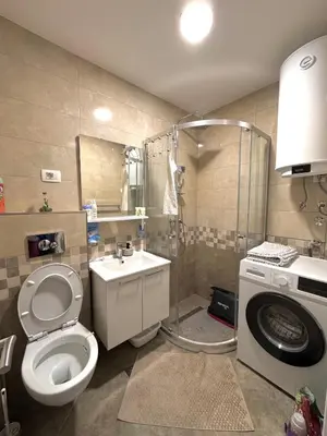 a bathroom with a toilet and a washing machine at Apartment Simovic in Cetinje