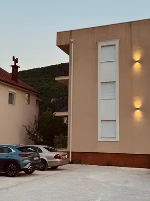 two cars parked in a parking lot next to a building at Apartment Simovic in Cetinje