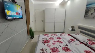 a room with a bed and a tv in a room at AJKULICA Apartman in Bar