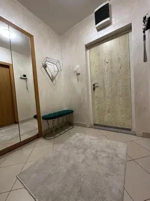 a bathroom with a door and a stool and a rug at IN apartment in Podgorica