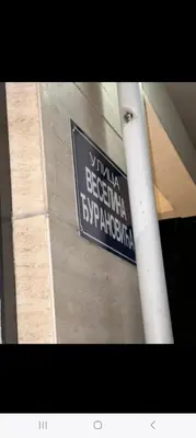 a blue and white street sign on a pole at City kvart 2 bedroom apartment in Podgorica