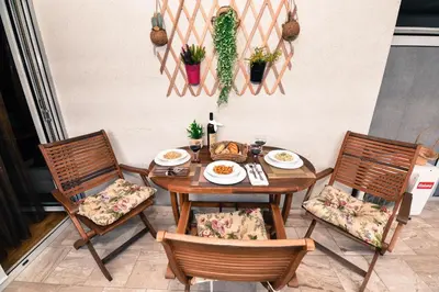 a wooden table with two chairs and a table with food on it at Apartment Godfather in Budva