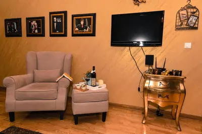 a living room with a chair and a tv and a table at Apartment Godfather in Budva