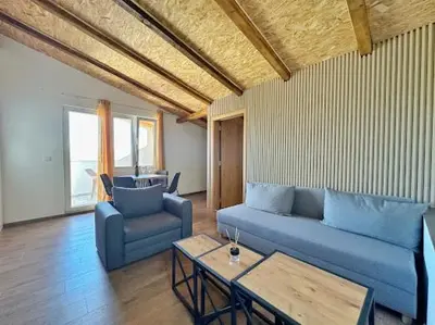 a living room with a blue couch and a table at Luxurious attic apartment with a breathtaking view in Vranjina