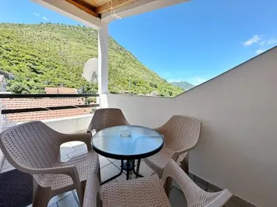 a table and chairs on a balcony with a view at Luxurious attic apartment with a breathtaking view in Vranjina