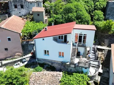 a small white house with a red roof at Luxurious attic apartment with a breathtaking view in Vranjina